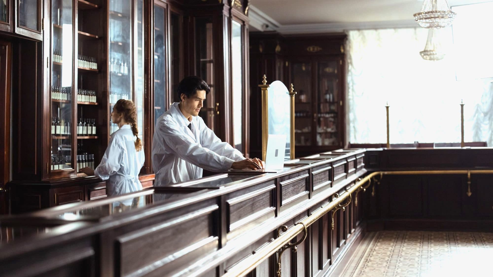 Pharmacists working behind the counter of a traditional European dispensary