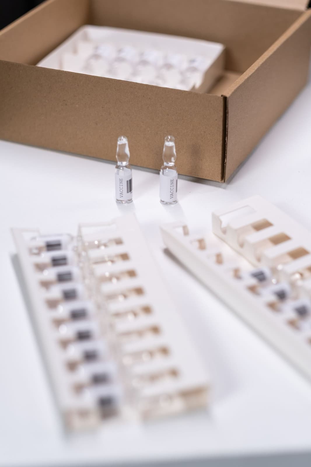 Glass ampoules in a tray beside a carton