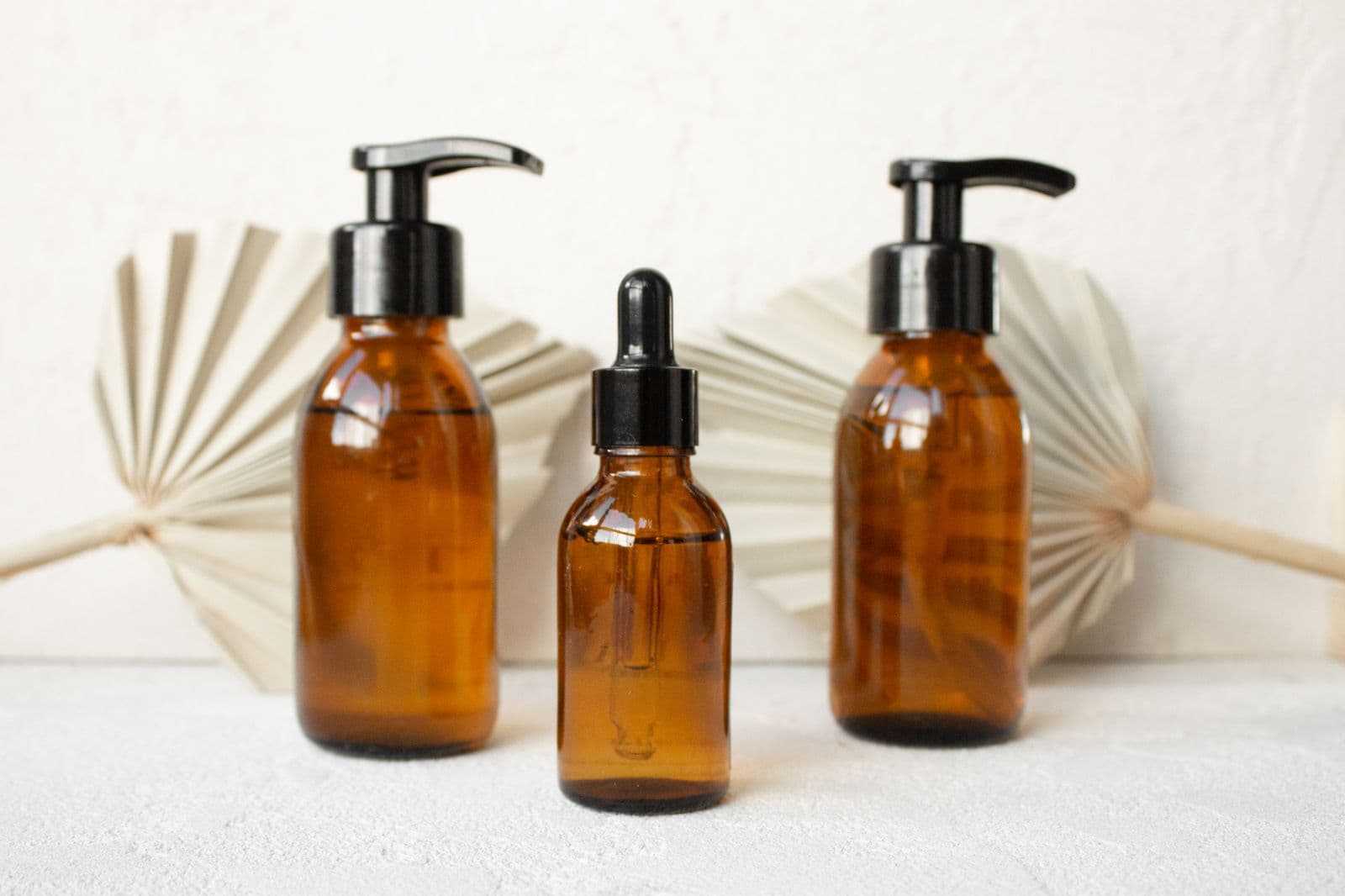 Amber glass pump bottles and a dropper bottle of liquid formulations